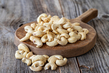 Roasted Cashews. Cashew nuts on wood background. Bulk Cashews.