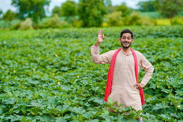 Young Indian farmer at green agriculture field.