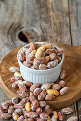 Salted Roasted Peanuts. Peanuts on wood floor. Bulk peanut kernels. Peanuts on a ceramic plate