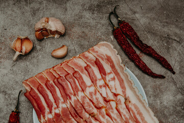 fresh sliced bacon on a gray stone background