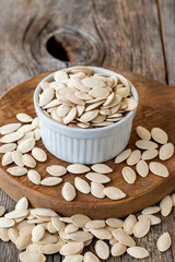 Shelled Pumpkin seeds. Pumpkin seeds on wood background. Bulk Pumpkin Seeds. Pumpkin seeds on ceramic plate