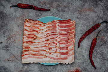 fresh sliced bacon on a gray stone background