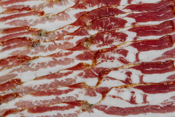 Texture background of thinly sliced bacon close-up