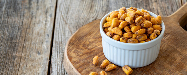 Roasted corn snack. Corn nuts with sauce on wood background. bulk corn nut grains. Copy space
