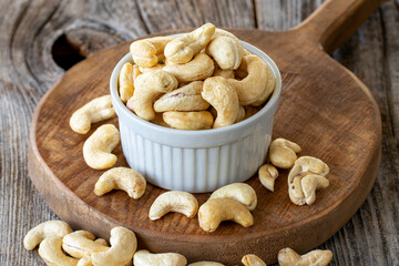 Roasted Cashews. Cashew nuts on wood background. Bulk Cashews.