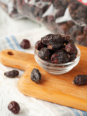 Dried rose hips in a glass bowl. Close-up. Macro. Light background.