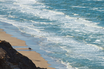 Two people are walking on the beach. The north sea coast in Denmark from the birds eye view. 