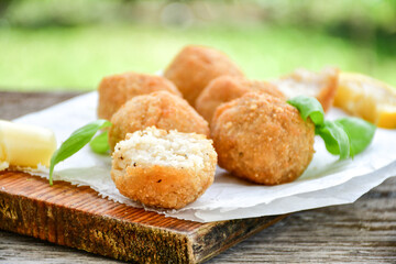 Italian arancini Cacio e pepe. Home-made rice balls with mozzarella cheese, parsley, lemon, and parmesan cheese.