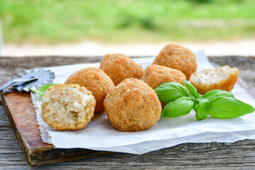 Italian arancini Cacio e pepe. Home-made rice balls with mozzarella cheese, parsley, lemon, and parmesan cheese.