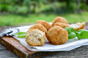 Italian arancini Cacio e pepe. Home-made rice balls with mozzarella cheese, parsley, lemon, and parmesan cheese.