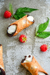  Sicilian cannoli . Тypical  italian   home made dessert with ricotta cheese, chocolate and raspberryes on wooden background