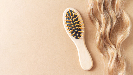 Blond wavy hair lock and bamboo comb brush - obrazy, fototapety, plakaty