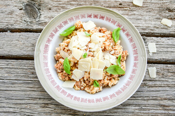 Italian  bolognese risotto with parmesan cheese on rustic background