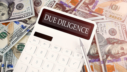 DUE DILIGENCE text on display calculator on dollars background