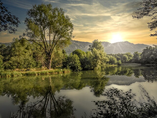 Fototapeta na wymiar Coucher de soleil sur un lac au milieu des bois avec les reflets de la nature