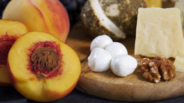 Cheese plate served with grapes and nuts. Assorted cheeses camembert, brie, parmesan blue cheese, goat with grapes, gressini sticks, cashews, honey and jam.