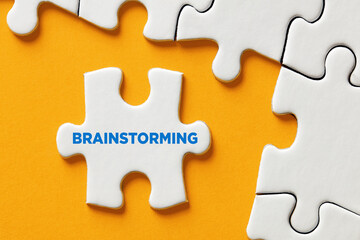 Fototapeta premium The word brainstorming written on a puzzle piece. To find a creative solution by teamwork