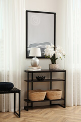 Blooming orchid and lamp on console table indoors. Interior design