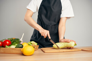 Woman in black apron slicing vegetables kitchen cooking food