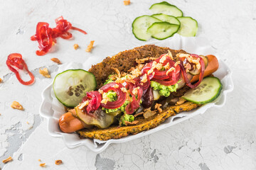 Healthy vegetarian hot dog with flatbread made from vegetables, topped with red onions, pickles and pea puree, white background