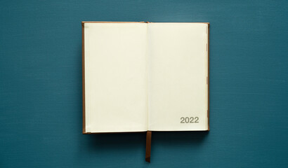 calendar 2022 with space for text, notebook, brown tab, on a painted background, photo from above