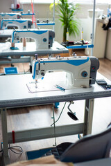Interior of garment factory . Closes making atelier with several sewing machines. Tailoring industry, fashion designer workshop, industry concept