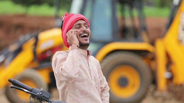 Young indian farmer talking on smartphone