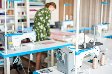 Interior of garment factory . Closes making atelier with several sewing machines. Tailoring industry, fashion designer workshop, industry concept