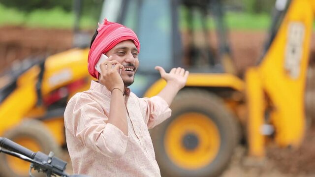 Young indian farmer talking on smartphone