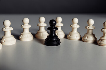 Leadership and business concept, black pawn of chess standing out from the crowd of white