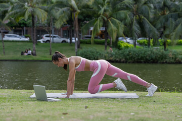 Fototapeta premium Pretty young woman doing sport exercises in the park. Pink sportswear. Healthy lifestyle. Quarantine. High quality photo 