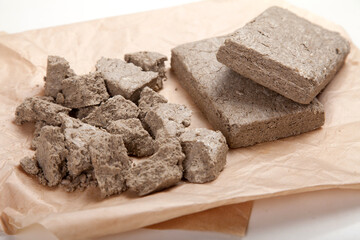 Halva in briquettes and in large pieces lies on craft paper.