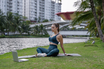 Fototapeta na wymiar Yoga exercise - woman doing yoga pose meditation in the public park. Sport healthy concept. Beautiful shapes. 