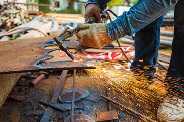 Male worker metal cutting spark on tank bottom steel plate with flash of cutting light