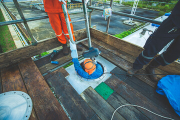 Male worker climb inside the stairway storage visual inspection tank