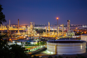 Obraz premium Tank crude oil scene of refinery plant and tower column of evening​ sunset Petrochemistry industry