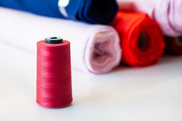 Fashion Design Studio. Hanging Clothes, Sewing Machine and Various Sewing Related Items on the Table, Mannequins Standing, Colorful Fabrics.