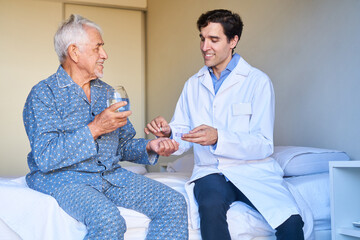 Obraz premium Krankenpfleger verteilt Tabletten an kranken Senior