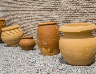 Old large jugs on a wall background