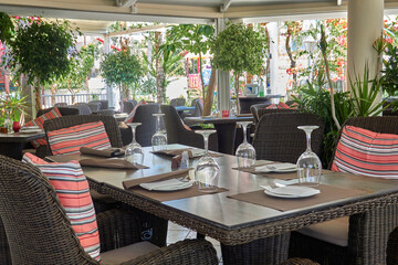 Stylish cafe with decor of green living plants, table and chairs without visitors.