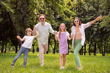 Obraz premium Photo of pretty sweet father mother school girl boy wear casual clothes walking holding arms smiling outdoors countryside forest