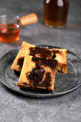 Tea Time with Slice of Marble Travel Cake, Square Cake with Melted Chocolate on the Center. Served on Rustic  Plate