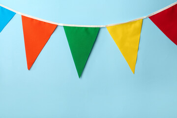Bunting with colorful triangular flags on light blue background