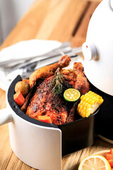 Homemade Roasted Whole Chicken with Lemon, Rosemary, Vegetable on Air Fryer. Copy Space for Text