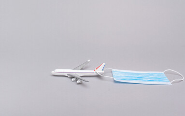 Airplane model and mask. The reality of a pandemic. COVID-19.