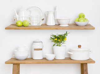 Kitchen shelf and table with utensils, pots and green apples
