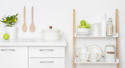 Fototapeta na wymiar Kitchen storage drawers and shelves with ceramic and wooden dishware