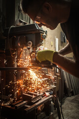 Craftsman with electric grinder tool on steel structure in factory