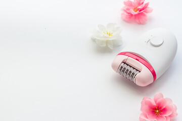 Epilator with pink and white flowers. Hair removal and depilatory concept