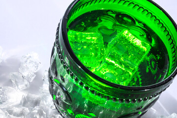 A vessel, a wide glass of green glass with a volumetric pattern along the entire outer perimeter, in the middle there is a pattern - an ornament, at the top and at the base are geometric.